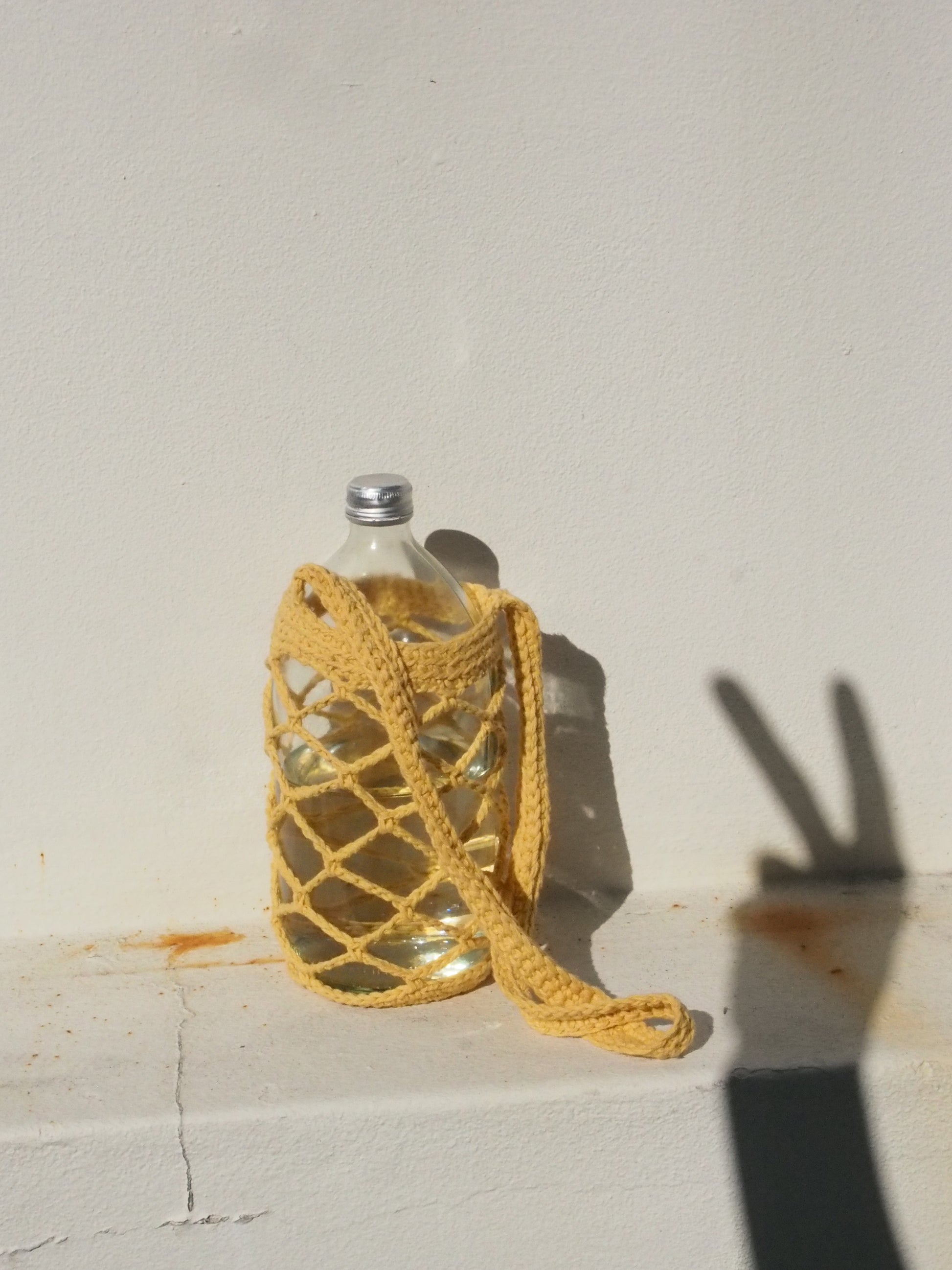 1 litre cotton crochet bottle sling in Yellow. 